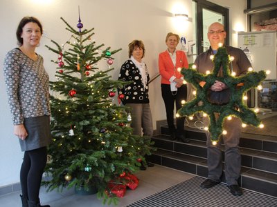Avacon-Kommunalreferentin Antje Klimek (von links), Rathausmitarbeiterin Corinna Neuhoff, Bürgermeisterin Steffi Trittel und Bauamtsleiter Rüdiger Schmidt bei der Übergabe des LED-Weihnachtssternes.