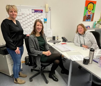 Rathausmitarbeiterin Katja Salomon (links) und Marlies Böttcher (rechts) begrüßen die neue Kitabereichsleiterin II Sabrina Lindenau (Mitte) an ihrem Arbeitsplatz. 