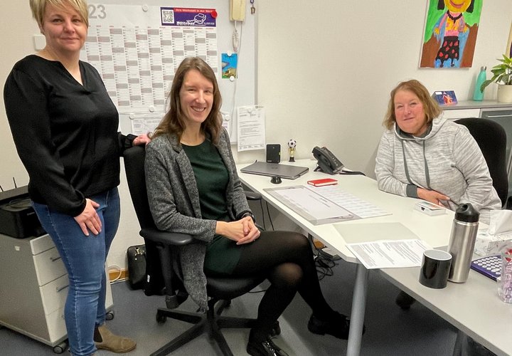 Rathausmitarbeiterin Katja Salomon (links) und Marlies Böttcher (rechts) begrüßen die neue Kitabereichsleiterin II Sabrina Lindenau (Mitte) an ihrem Arbeitsplatz. 