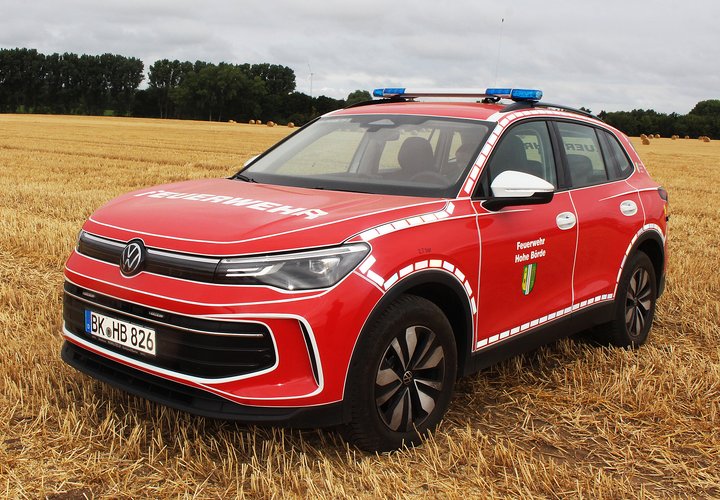 Roter Pkw der Feuerwehr auf einem Feld.
