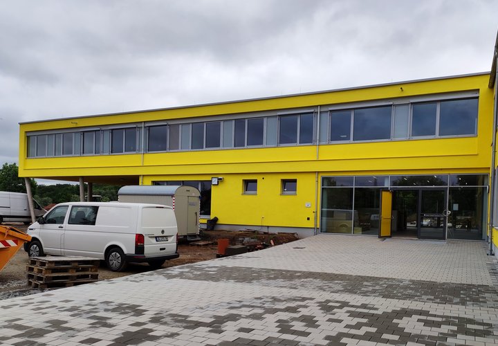 Blick auf ein modernes gelbes Schulgebäude 